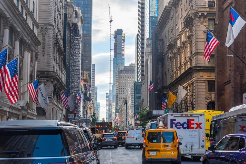 Traffic jam on 5th Avenue in Manhattan, New York City with One World Trade Center tower under construction visible in background.